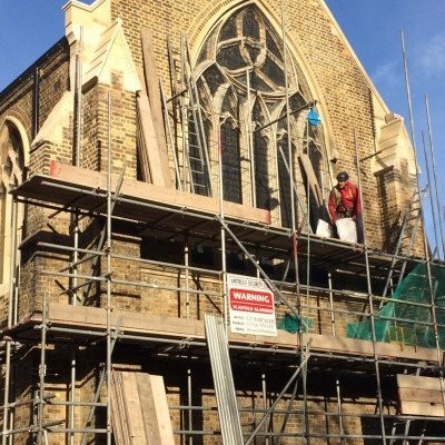 Removal of scaffolding from east end shows new stonework and window guard